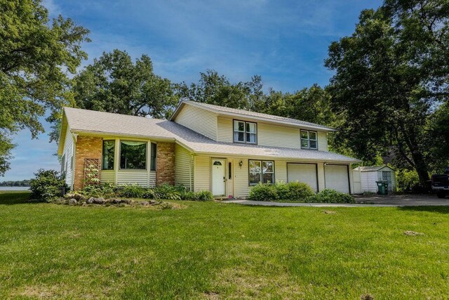 view of front facade featuring an attached garage, driveway, and a front yard