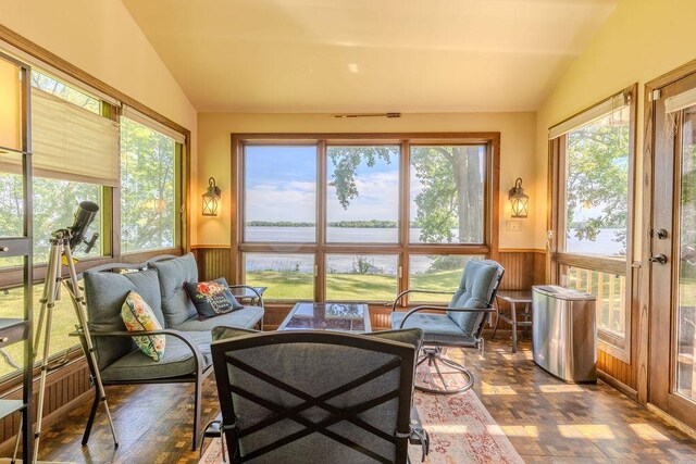 sunroom / solarium featuring a water view and lofted ceiling