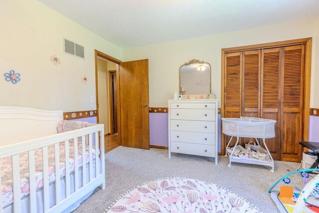 bedroom featuring light colored carpet, a closet, and visible vents