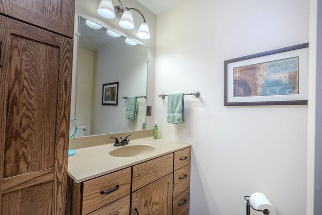 bathroom with an inviting chandelier and vanity