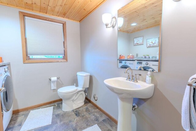 half bathroom with toilet, wooden ceiling, baseboards, and washer / clothes dryer