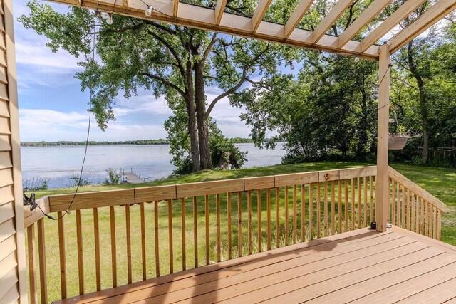 wooden terrace with a yard and a water view