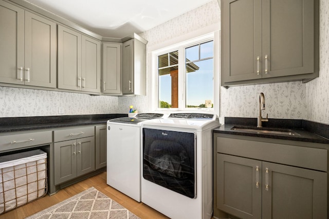 washroom with sink, separate washer and dryer, cabinets, and light hardwood / wood-style floors