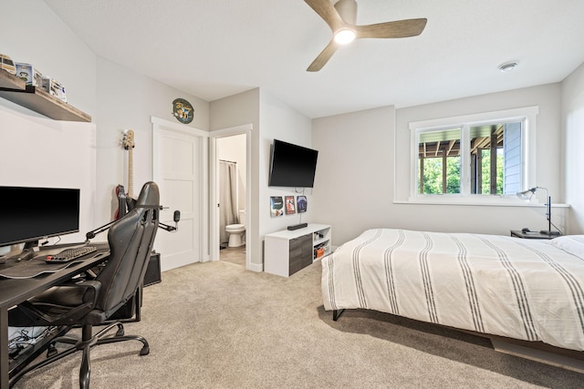 bedroom featuring ensuite bathroom, light colored carpet, and ceiling fan