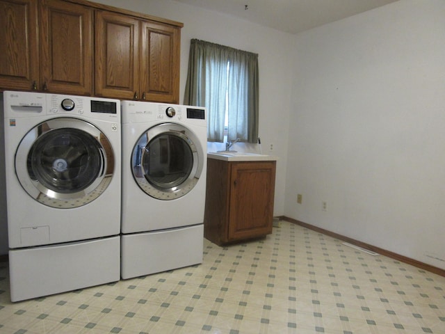 washroom featuring cabinets, sink, and washing machine and clothes dryer