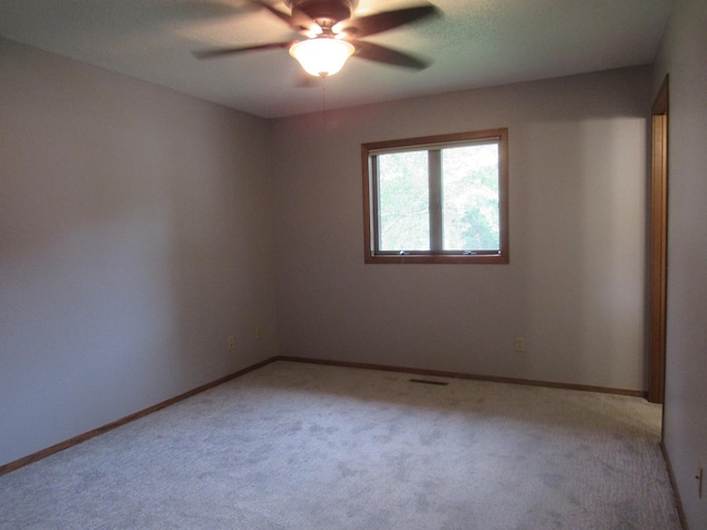 unfurnished room with ceiling fan and light colored carpet