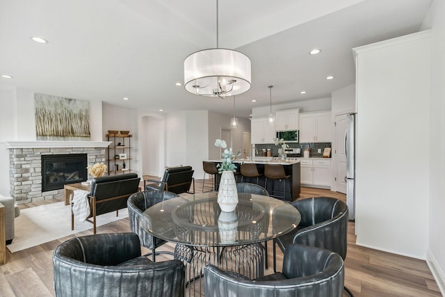 dining space featuring light wood-type flooring and a fireplace