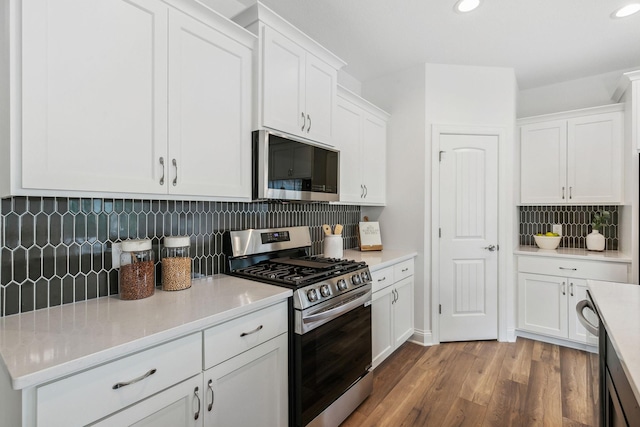 kitchen featuring white cabinets, appliances with stainless steel finishes, light hardwood / wood-style floors, and tasteful backsplash