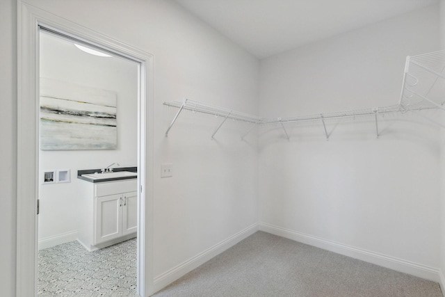 walk in closet featuring sink and light tile patterned floors