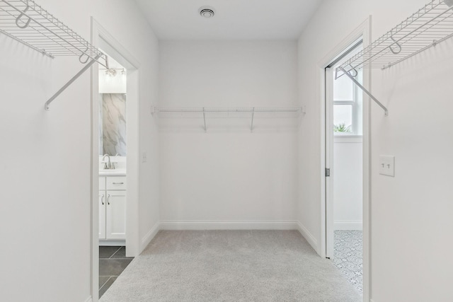 walk in closet featuring sink and tile patterned floors