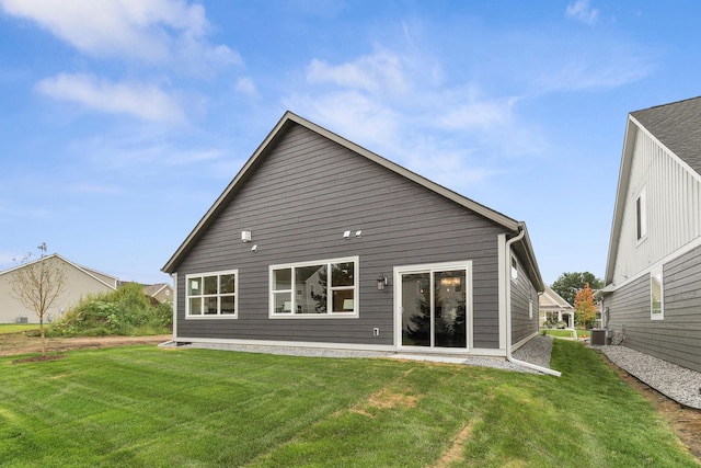 rear view of house with a yard and cooling unit