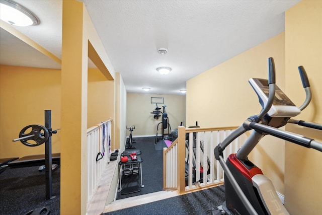 exercise room featuring a textured ceiling and carpet