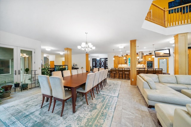 dining room featuring a chandelier, light tile patterned floors, and ornate columns