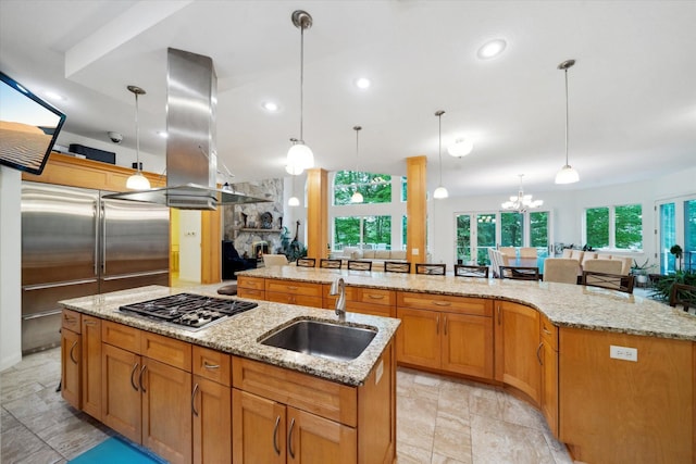 kitchen featuring a spacious island, island range hood, sink, and decorative light fixtures