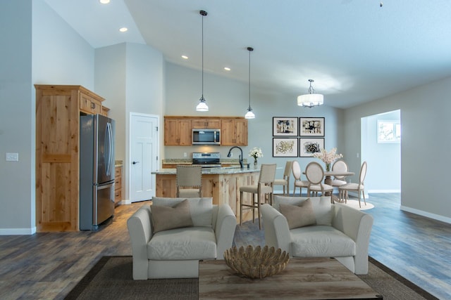 living room with dark wood-type flooring, sink, a notable chandelier, and high vaulted ceiling