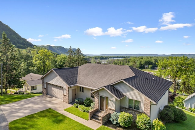 single story home featuring a mountain view, a front lawn, and a garage