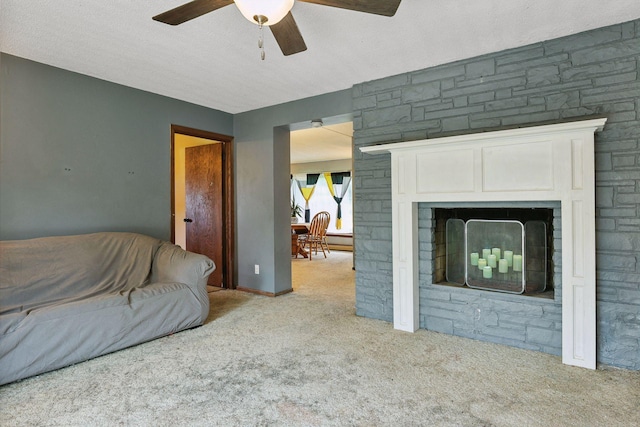 carpeted living room with a fireplace, a textured ceiling, and ceiling fan