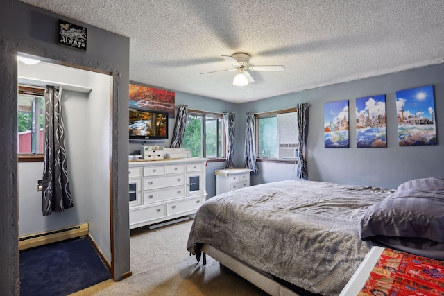 carpeted bedroom featuring a baseboard heating unit, a textured ceiling, and ceiling fan