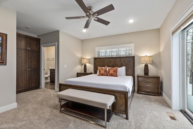 carpeted bedroom with ensuite bathroom and ceiling fan