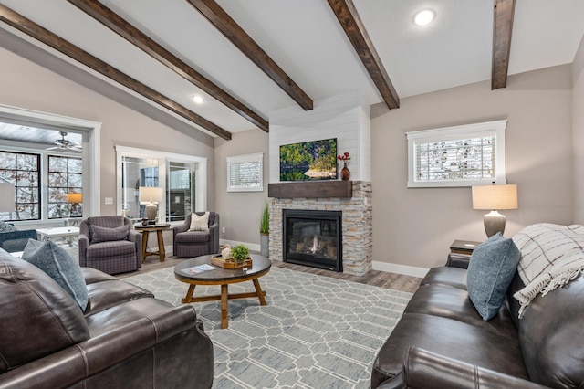 living room featuring lofted ceiling with beams, light wood-type flooring, and a fireplace