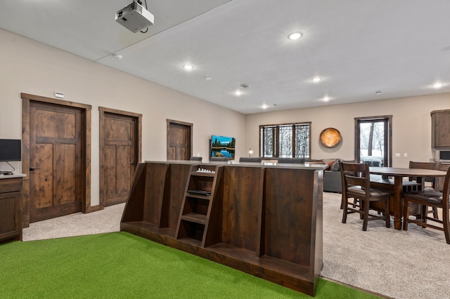 kitchen featuring light colored carpet, dark brown cabinetry, and kitchen peninsula