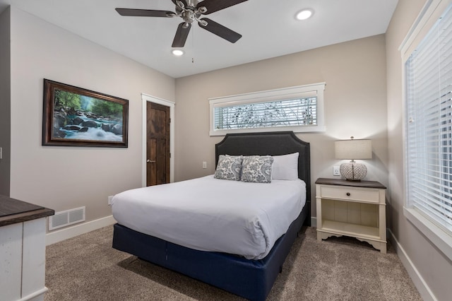 bedroom with ceiling fan and dark carpet