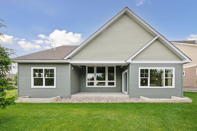 back of property featuring a patio area and a lawn