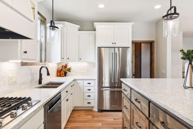 kitchen featuring pendant lighting, white cabinetry, sink, and appliances with stainless steel finishes