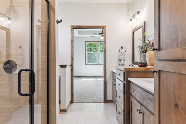 bathroom with tile patterned floors, ceiling fan, vanity, and a shower with shower door