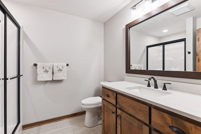 bathroom featuring toilet, a textured ceiling, an enclosed shower, and vanity