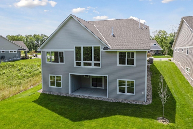 rear view of property with a patio, a yard, and central AC