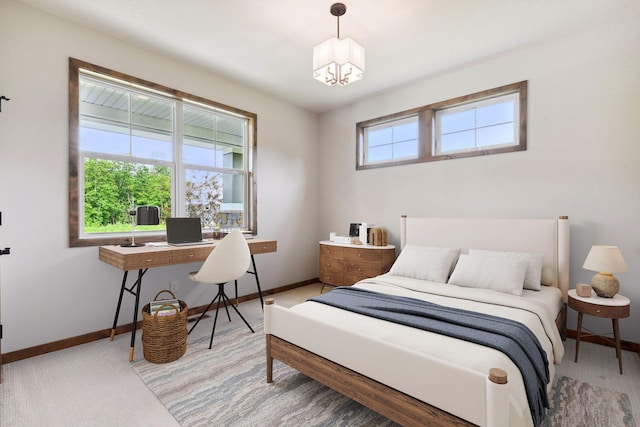 bedroom featuring light carpet and a chandelier