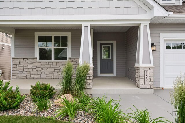 property entrance featuring a garage and covered porch