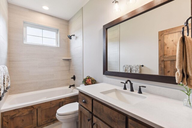 full bathroom featuring vanity, toilet, and tiled shower / bath