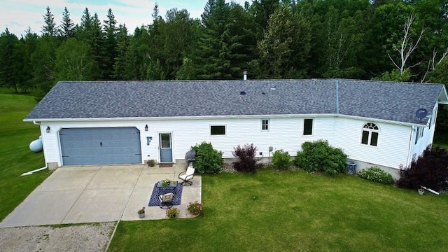 single story home with a front yard, a garage, and driveway