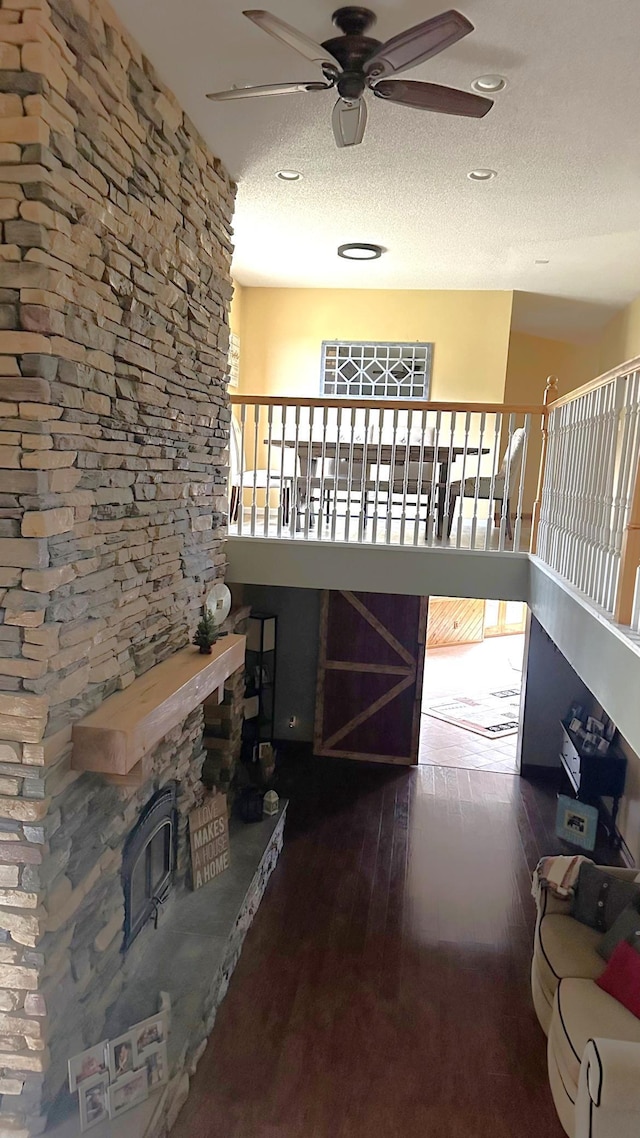 living room with wood-type flooring, a ceiling fan, recessed lighting, and a textured ceiling