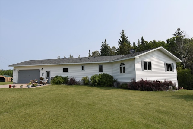 view of front facade with an attached garage, concrete driveway, and a front yard
