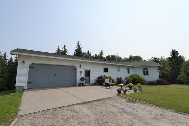 ranch-style house featuring a garage, driveway, and a front lawn
