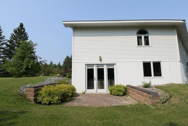 back of property with a lawn, french doors, and a patio area