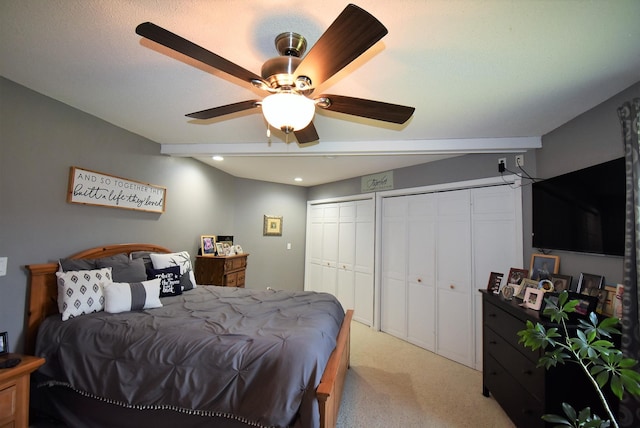 bedroom with light colored carpet, recessed lighting, multiple closets, and a ceiling fan