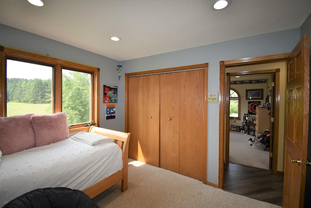 carpeted bedroom with a closet and recessed lighting
