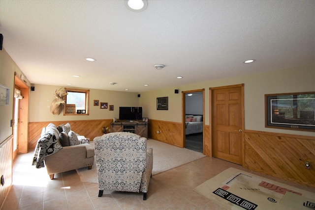 living area with recessed lighting, wood walls, and wainscoting