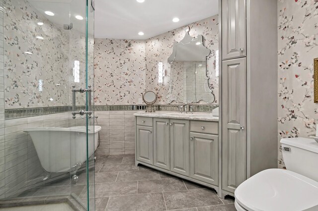 full bathroom featuring shower with separate bathtub, vanity, tile patterned flooring, tile walls, and toilet