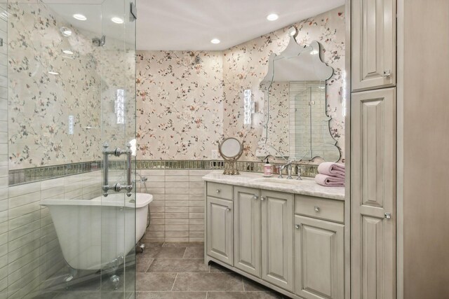 bathroom featuring plus walk in shower, tile patterned floors, vanity, and tile walls