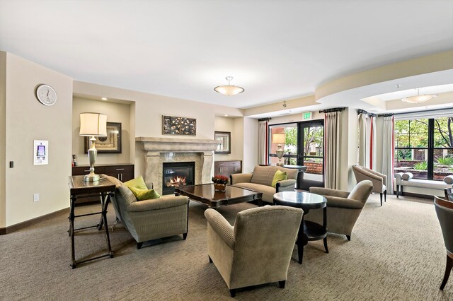 carpeted living room featuring a wealth of natural light and a high end fireplace