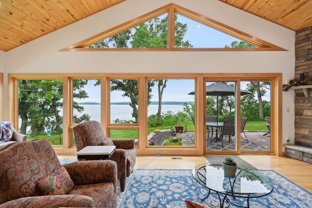 living room with wooden ceiling, a water view, light hardwood / wood-style flooring, and high vaulted ceiling