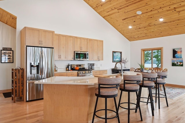 kitchen with light brown cabinetry, wooden ceiling, appliances with stainless steel finishes, and an island with sink