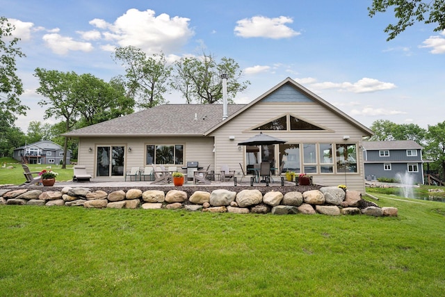 back of property with a lawn and a patio