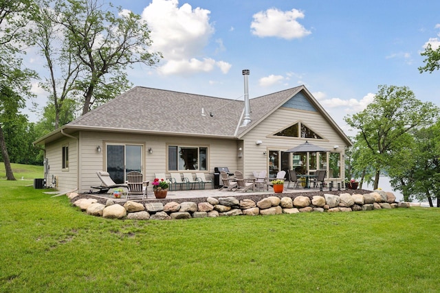 rear view of house with a lawn and a patio