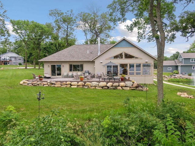 rear view of property featuring a yard and a patio